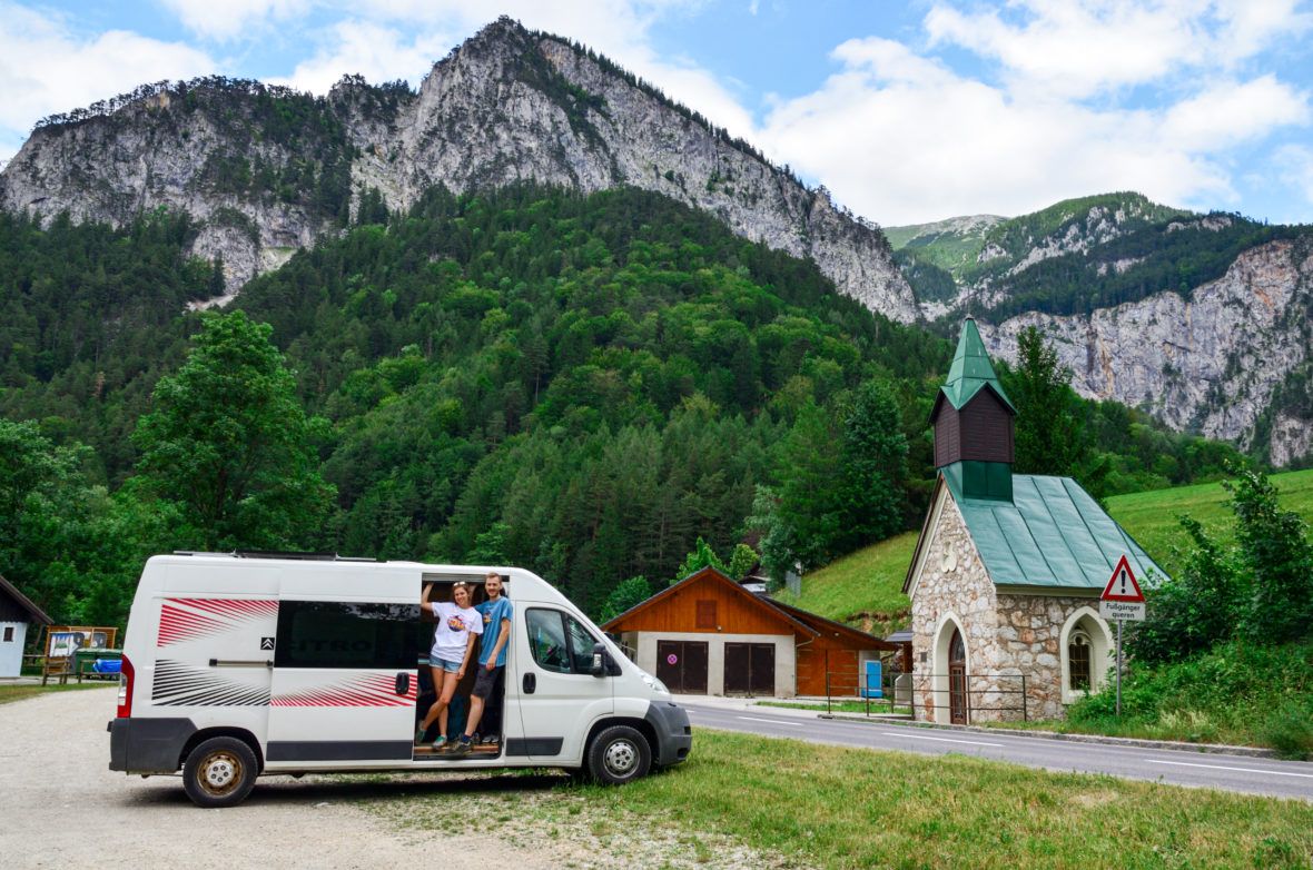 Ewa i Marcin stoją w busie na parkingu w Dolinie Hollental, w tle są góry a obok kapliczka