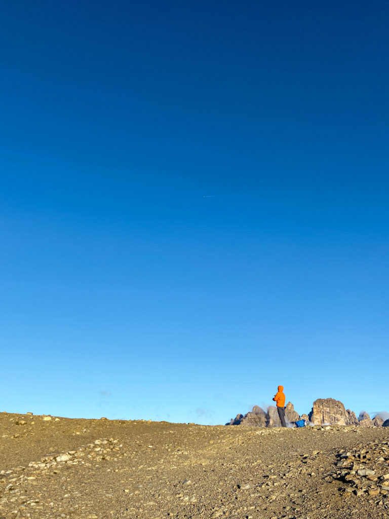 Marcin stoi na Przełęczy Lavaredo, za nim jest niebieskie niebo