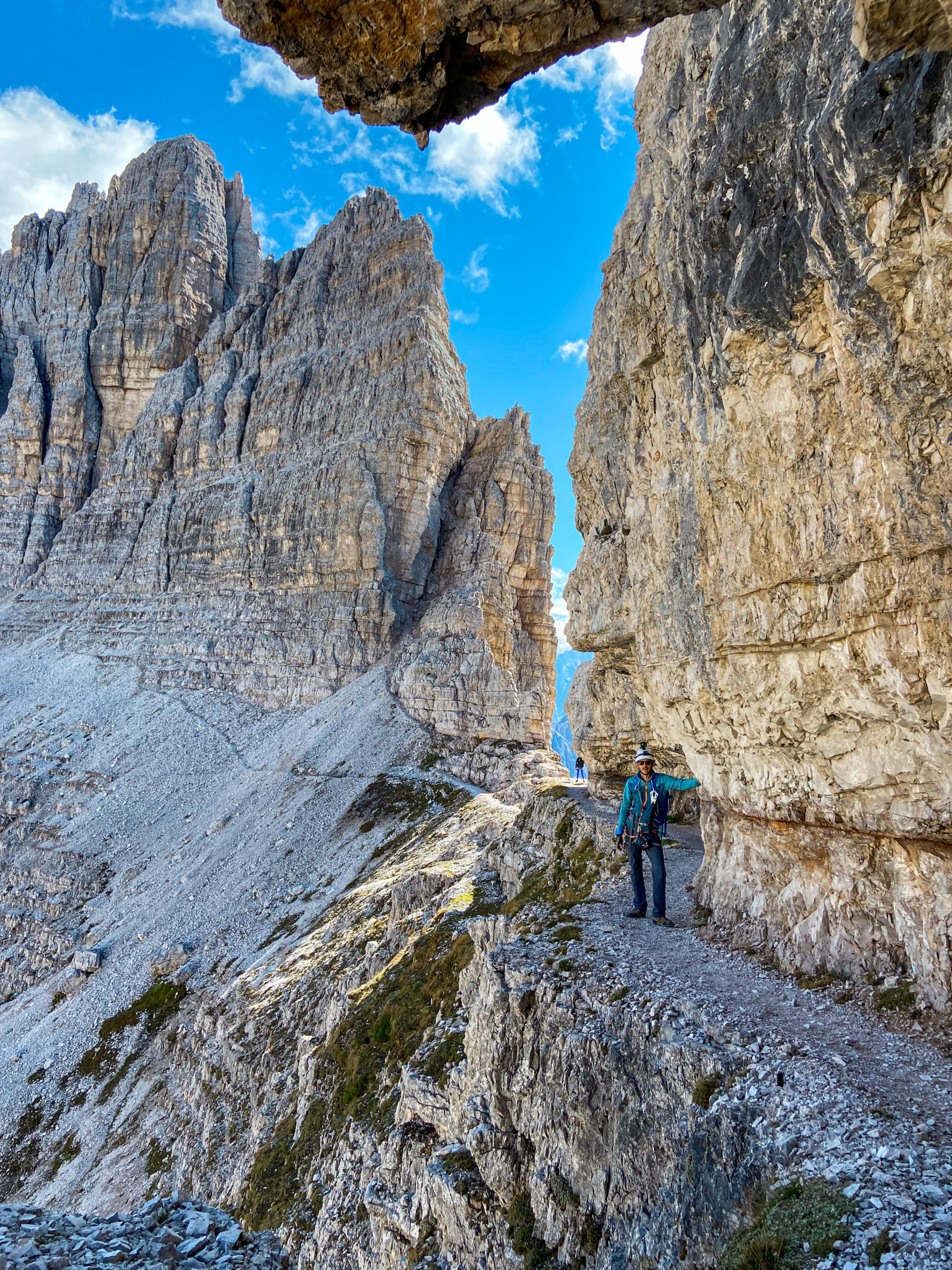 Marcin stoi na półce skalnej podczas zejścia z Monte Paterno