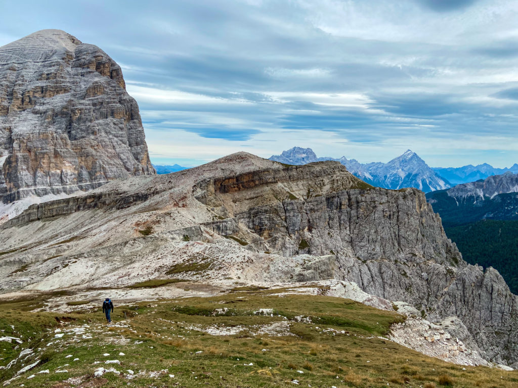 Marcin idzie płaskim grzbietem góry, a tle widzimy masyw Tifany di Rozes. Zdjęcie zrobione podczas zejścia z ferraty degli Alpini