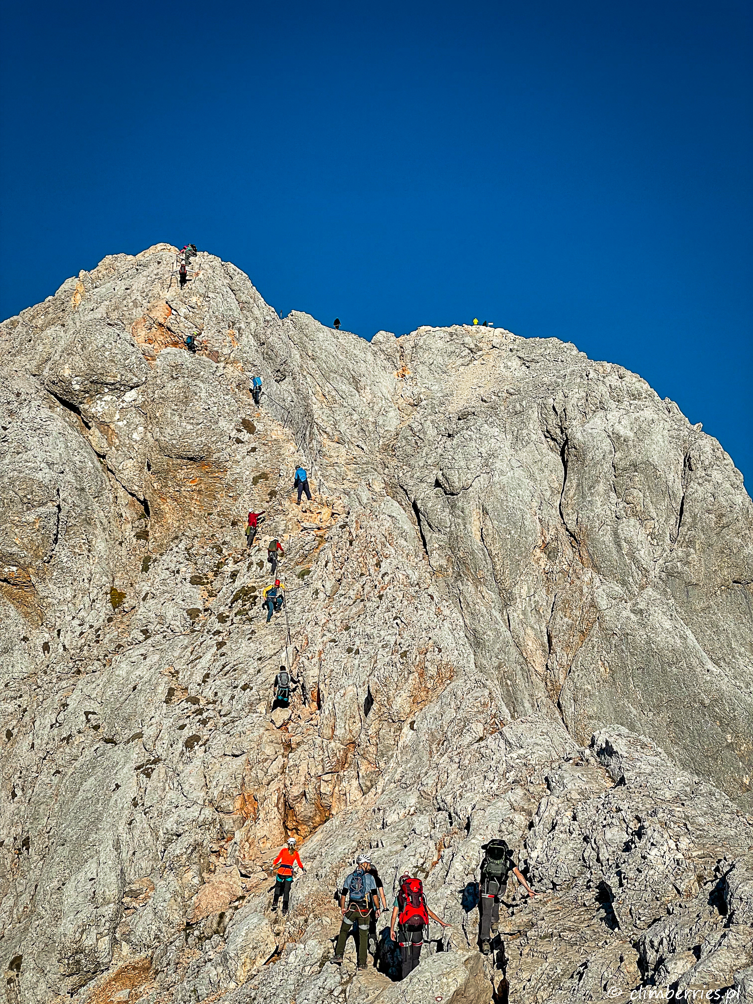 Ludzie wspinają się na Triglav skalną ścianą