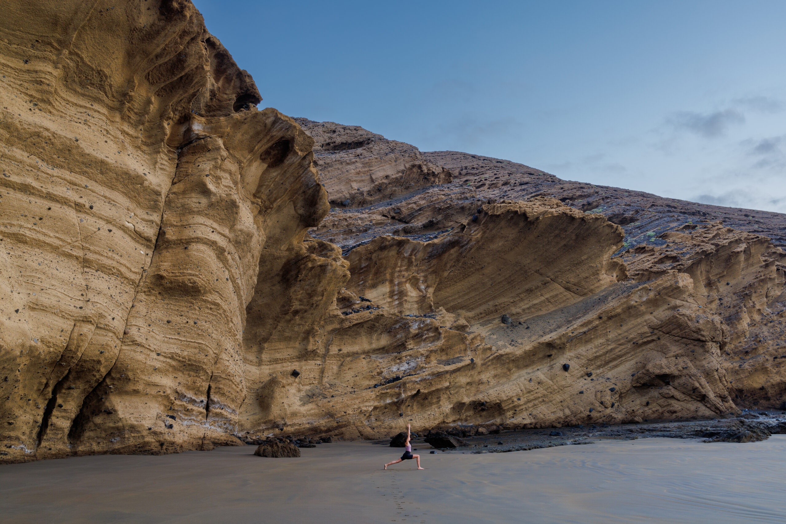 Ewa stoi w pozycji jogi na plaży Montana Pelada na Teneryfie, za nią znajdują się zjawiskowe skały; , Teneryfa - najpiękniejsze plaże