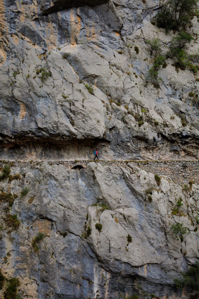 Ewa idzie skalną półką na szlaku Ruta del Cares. 