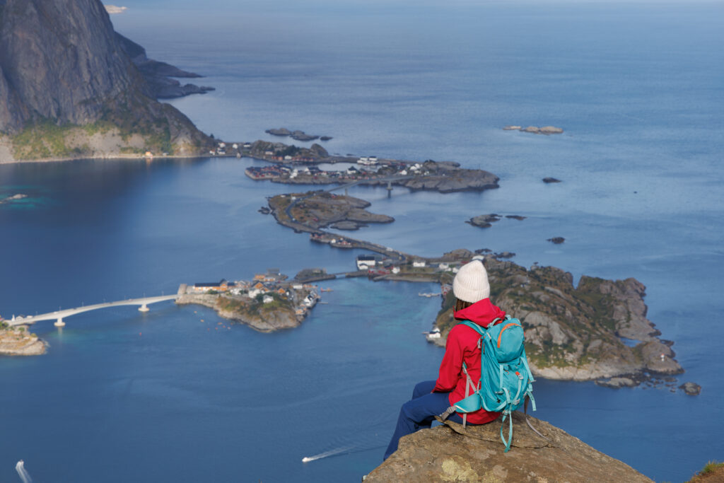 Ewa siedzi na Reinebringen z widokiem na fjord i wyspy