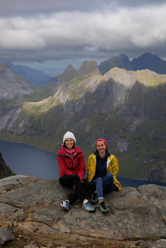 Ewa i Sylwia siedzą na szczycie Munknen, a nimi widać góry i fiord